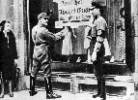 Dos nazis colocan un rótulo en el escaparate de una tienda judía. Éste dice: alemanes, resistid, no compréis a los judíos. Ampliar imagen