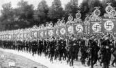 Desfile de soldados alemanes portando estandartes con los símbolos nazis. Ampliar imagen